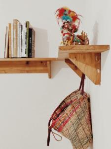une étagère en bois avec des livres et un panier dessus dans l'établissement Casa nel borgo, à Domaso