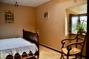 a bedroom with a bed and a chair and a window at Chez Lucien in Trébas