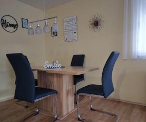 a table with two chairs and a smile sign on the wall at Haus Lucky in Rosenau am Hengstpass +14 photos