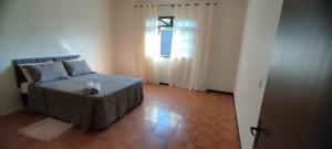 a small bedroom with a bed and a window at Casa Ponte Serrada in Joinville