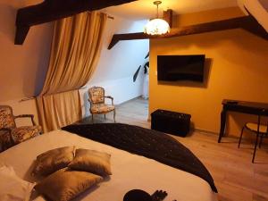 a bedroom with a bed and a desk and a television at Le Saloon de Rose in Valenciennes
