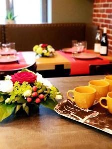 a table with a bouquet of flowers and cups on it at Le Saloon de Rose in Valenciennes +12 photos
