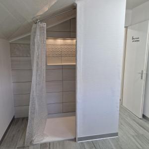 a walk in closet with a white shower curtain at Appartement Elielo in Étival-Clairefontaine +9 photos