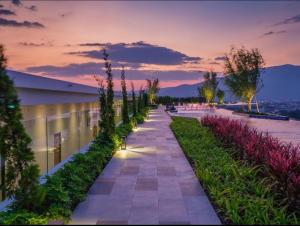 a walkway with plants on a building at sunset at The Astra Sky River Chiang Mai 宜居4人 无边泳池 乳胶床垫 in Chiang Mai