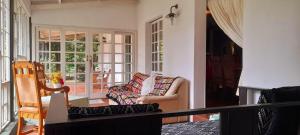 una sala de estar con un sofá y una silla en The Dutch House, en Dullstroom