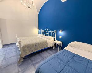 sypialnia z łóżkiem i niebieską ścianą w obiekcie Sognando Vietri e SPA Esclusiva P T w mieście Aversa