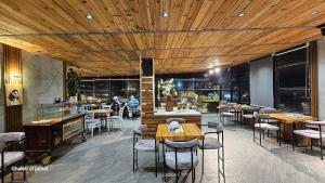 a restaurant with wooden ceilings and tables and chairs at Azmal Hotel & Suites in Irbid