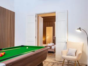 een woonkamer met een pooltafel en een stoel bij Villa Luciano - Rooftop Jacuzzi, BBQ, Billiards & Steps from Sea in Sliema