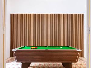 a green pool table in front of a wall at Villa Luciano - Rooftop Jacuzzi, BBQ, Billiards & Steps from Sea in Sliema