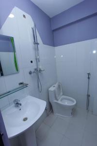 un bagno bianco con lavandino e WC di Paila Hostel Lakeside a Pokhara