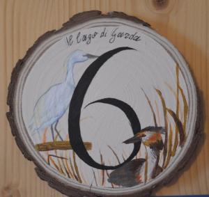 a painting of two birds on a plate on a wall at Affittacamere Porticciolo in Castelnuovo del Garda