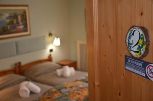 a bedroom with two beds and a sign on the wall at Affittacamere Porticciolo in Castelnuovo del Garda