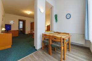 Pokój ze stołem i krzesłami oraz zegarem na ścianie w obiekcie Haus Alexander w mieście Heringsdorf