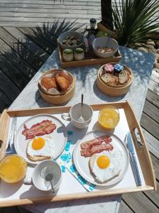モンタリヴェ・レ・バンにあるLes Bambousの卵ベーコンなどの朝食用食材を使用した朝食用テーブル