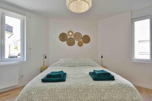 a bedroom with a bed with two green towels on it at Superbe appartement - Cosy à 10 min Centre ville in Schiltigheim +8 photos