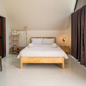 a bedroom with a large bed with white sheets at Kawaland glamping resort in Telukbakau +52 photos