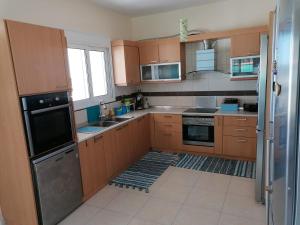 a kitchen with wooden cabinets and a stove top oven at Villa Klelia in Afantou +38 photos