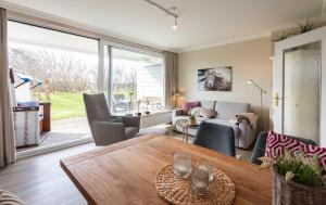 a living room with a wooden table and a living room at Strandlust im Haus Caecilia in Wenningstedt