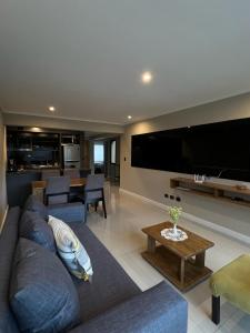 a living room with a blue couch and a large tv at Ballester's Dream in San Martín de los Andes
