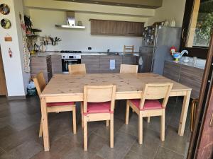 a kitchen with a wooden table and chairs at Etna Home Garden in Viagrande