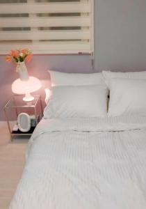 a bedroom with a white bed with a vase of flowers at Namsan Nest in Seoul +33 photos