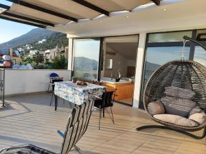 a patio with a table and chairs and a swing at Glennhouse in Kaş