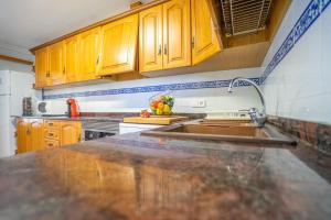 a kitchen with wooden cabinets and a sink at LAS COLUMNAS in Port de Pollensa +12 photos