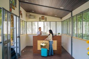 ShivpuriにあるPerfectstayz The Jungle Resort, Shivpuriのスーツケースを持つ女性とカウンターの男性 +68枚の写真