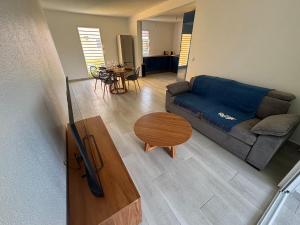 una sala de estar con un sofá y una mesa en L'écrin du Rivage, en Sainte-Anne