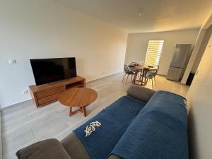 Una sala de estar con un sofá, un televisor y una mesa. en L'écrin du Rivage, en Sainte-Anne 7 fotos más