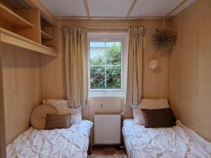 a bedroom with two beds and a window at 6 persoons chalet op de Veluwe bij binnen en buiten zwembad in Arnhem