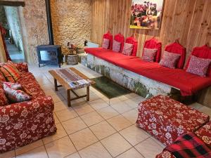 a living room with red couches and a fireplace at MOULIN DE L'HOSTE in Larzac +56 photos