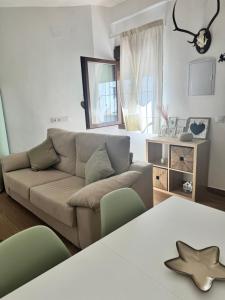 ein Wohnzimmer mit Sofa und Tisch in der Unterkunft La Casita de San Benito in Cazalla de la Sierra