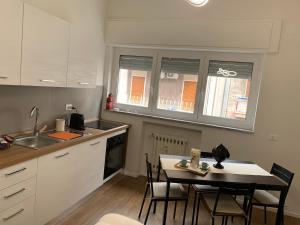 una cucina con tavolo, sedie e lavandino di Pizzoli Suite a Bari