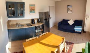 a kitchen and living room with a blue couch at appartement Terrasse KER HEOL - Proche centre Vannes in Vannes +10 photos