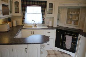 a kitchen with white cabinets and a black counter top at The Finest Hour in Cresswell