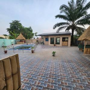 uma casa com um pátio de tijolos e uma piscina em EcoSignature ABK Hotel, Ibadan em Ibadan