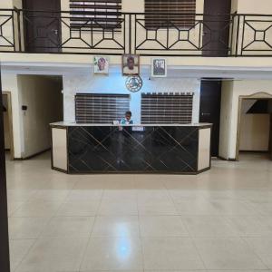 um homem parado atrás de um balcão num edifício em EcoSignature ABK Hotel, Ibadan em Ibadan