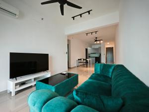 a living room with a green couch and a flat screen tv at Metropol Serviced Apartment - Bukit Mertajam, Penang in Bukit Mertajam