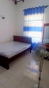 a room with a bed and a fan and a window at Sayuri Villa in Marawila