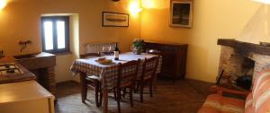 una sala da pranzo con tavolo, sedie e camino di Albergo Diffuso - Rocca Calascio a Calascio