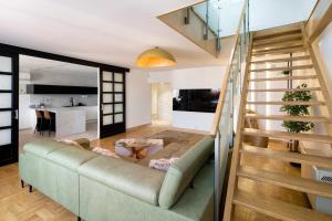 a living room with a couch and a staircase at Apartament w centrum - duplex penthouse in the centre with terrace and air conditioning in Krakow
