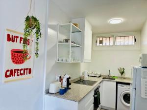 eine weiße Küche mit Spüle und Kühlschrank in der Unterkunft Costa Cunit Apartment in Cunit + 3 Fotos