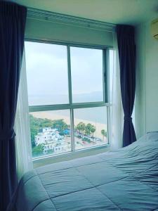 a bedroom with a bed and a large window at Seaview 1Bedroom 1Bathroom 33Sqm Floor14th Pattaya FO in Jomtien Beach
