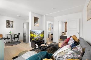 a living room with a couch and a flat screen tv at Nord Apartments in Trondheim +44 photos