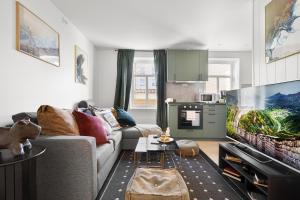 a living room with a couch and a tv at Nord Apartments in Trondheim