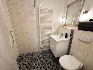 a bathroom with a white toilet and a sink at Komfortable und gepflegte Ferienwohnung für zwei bis vier Personen mit separatem Bad und separater Küche in Bad Segeberg