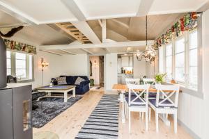 a dining room and living room with a table and chairs at Janebu - Premium RORBU Nusfjord in Ramberg