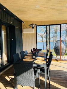 a dining table and chairs on a porch with a view at Lake House in Telšiai