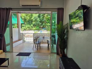 a living room with a table and a sliding glass door at Samed Your House Family Room in Ko Samed
